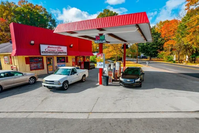 Batesville Corner Store gas station with cars refueling on a sunny autumn day.
